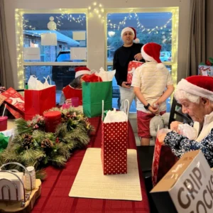 Forest Cottage Senior Care Christmas Party Passing Out Gifts To Residents